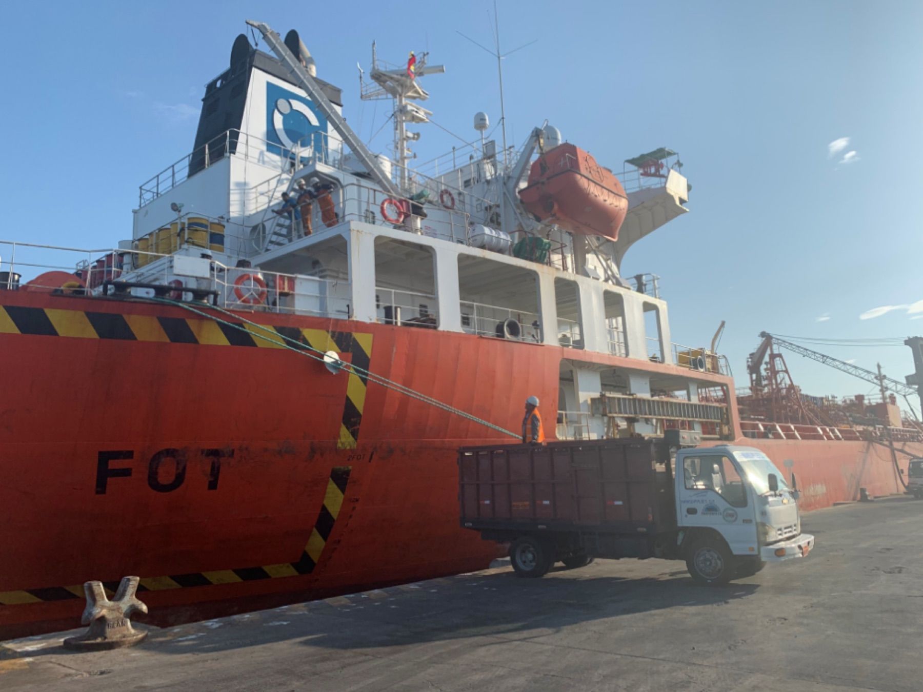 Camión de Mansupplies junto a un buque durante una operación portuaria